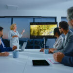 Executive leadership team reviewing performance metrics and workforce data during a high-level strategy meeting under operational pressure.