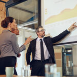 Executive leadership team reviewing Q1 performance metrics in a modern conference room setting.